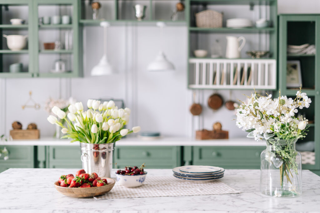 Tavolo da cucina con vasi di fiori e ciotole di frutta